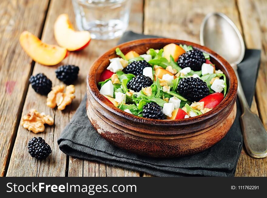 Arugula peach blackberry goat cheese salad. toning. selective focus