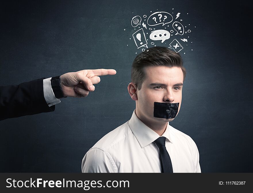 Caucasian business hand pointing at stressed male employee with drawn question, explamation marks, talk bubble above his head. Caucasian business hand pointing at stressed male employee with drawn question, explamation marks, talk bubble above his head