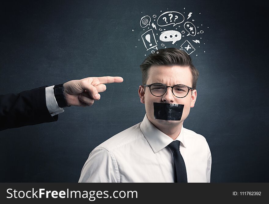 Caucasian business hand pointing at stressed male employee with drawn question, explamation marks, talk bubble above his head. Caucasian business hand pointing at stressed male employee with drawn question, explamation marks, talk bubble above his head
