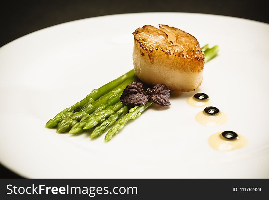 Scallop With Green Asparagus On White Plate