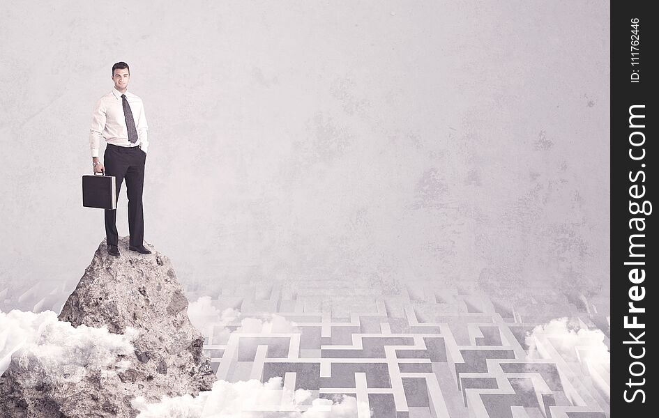 Businessman on cliff above labyrinth