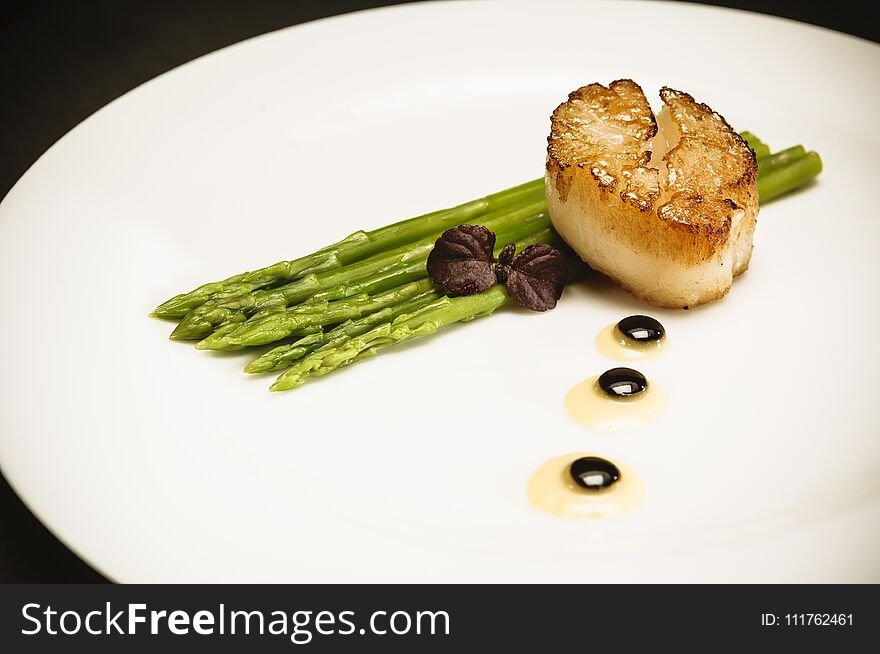 Scallop With Green Asparagus On White Plate