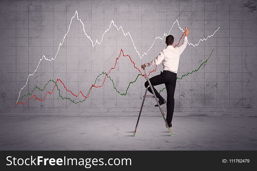 A guy in modern suit standing on a small ladder and drawing a chart on grey wall background with exponential progressing curves, lines. A guy in modern suit standing on a small ladder and drawing a chart on grey wall background with exponential progressing curves, lines