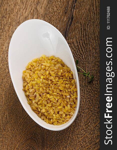 Raw bulgur heap in the bowl ready for cooking