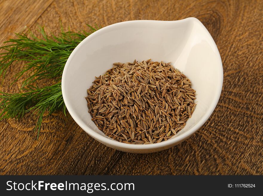 Cumin seeds heap on the wood background