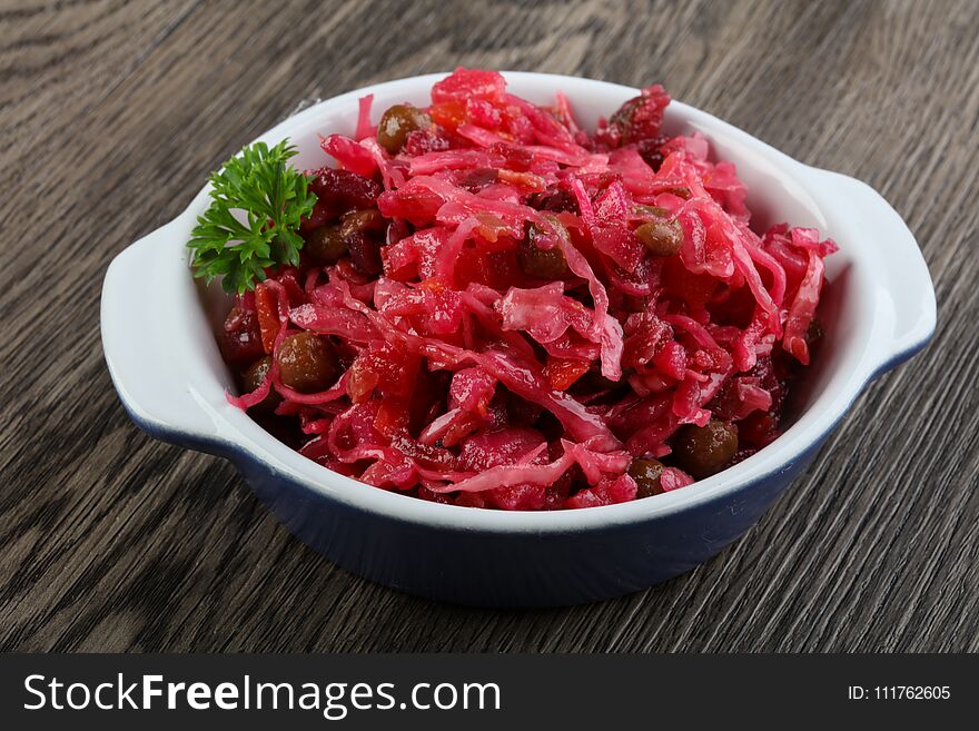 Viniagrette russian salad served parsley on wood background