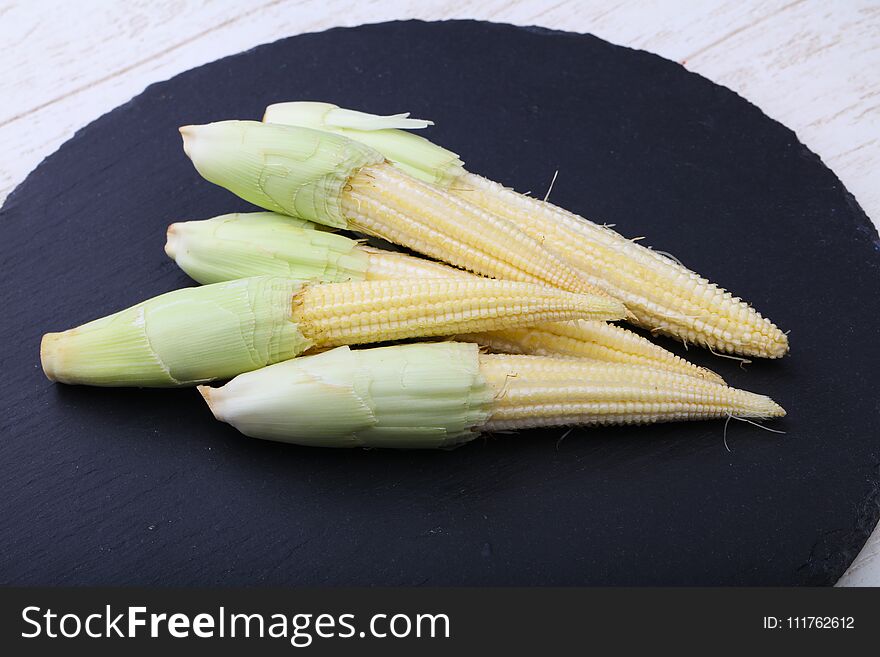 Fresh baby corn heap on the wood background