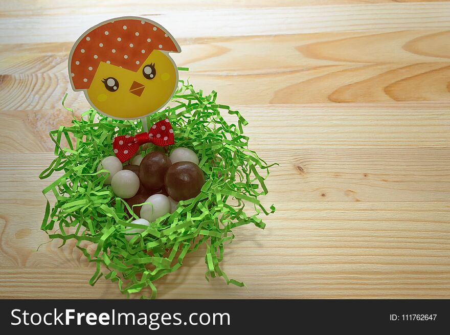 Candies in nest decorated with cute chicken and bow. Candies in nest decorated with cute chicken and bow