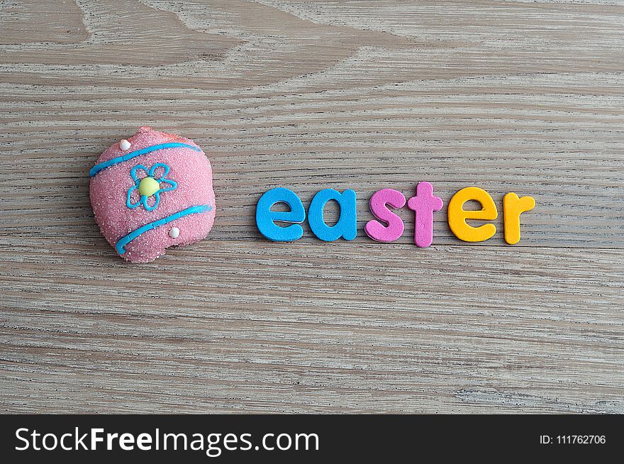 An egg shape marshmallow with the word easter on a wooden background