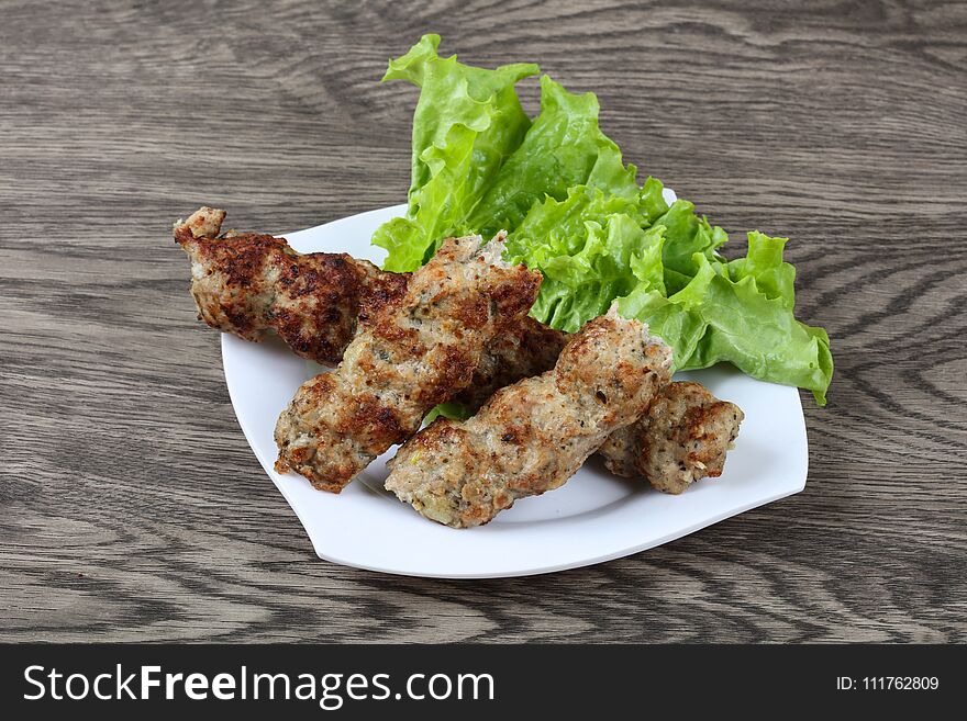 Meat kebab with green salad leaves