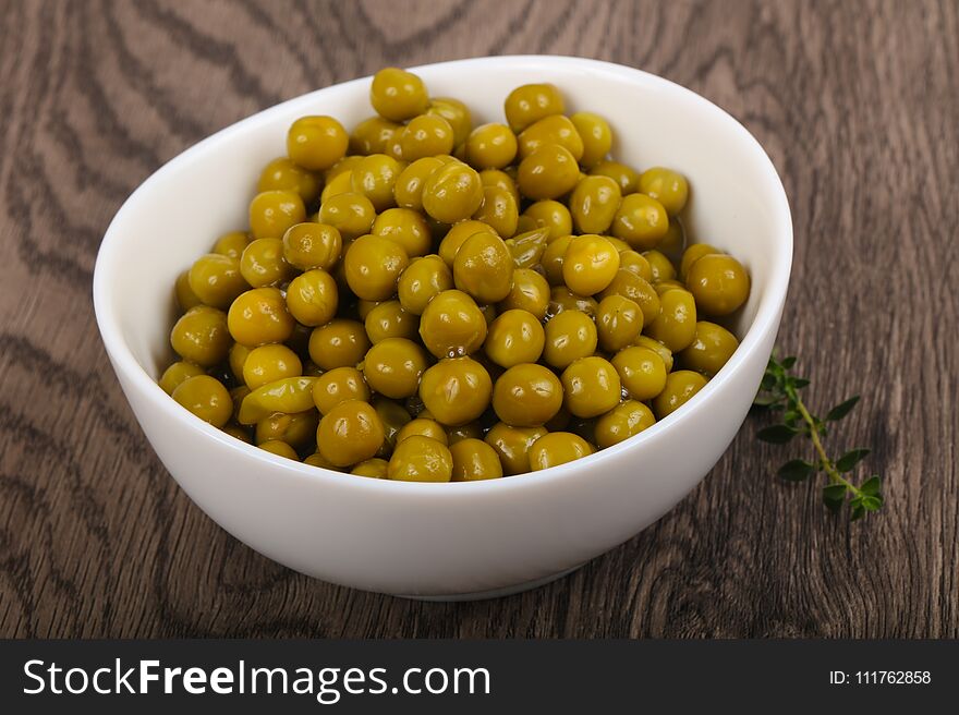 Pickled pea in the plate over wooden background