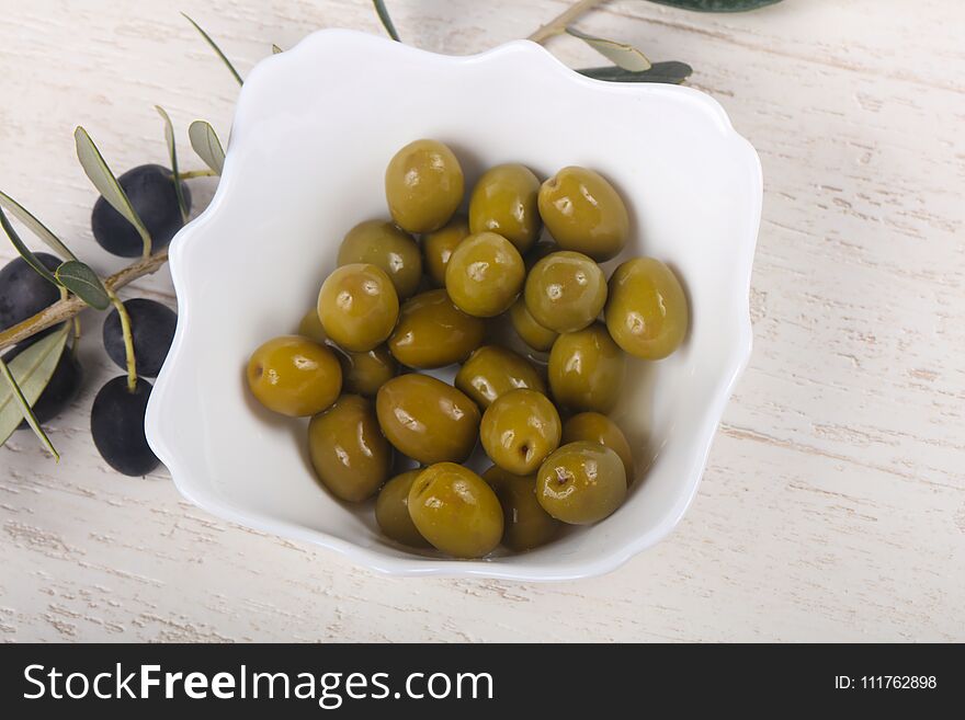 Green olives in the bowl served branch