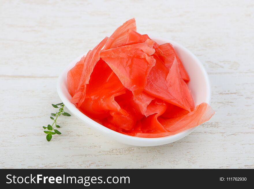 Pickled ginger in the bowl on wood background