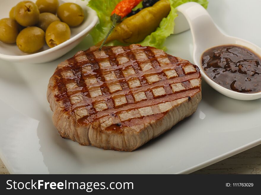 Grilled beef steak with pepper sauce and salad leaves