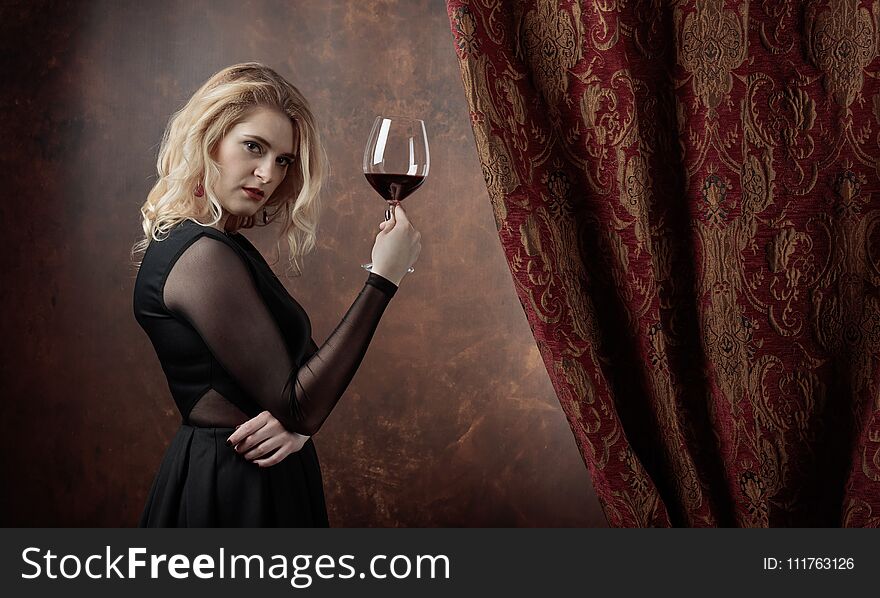 Portrait of beautiful young woman with red wine.