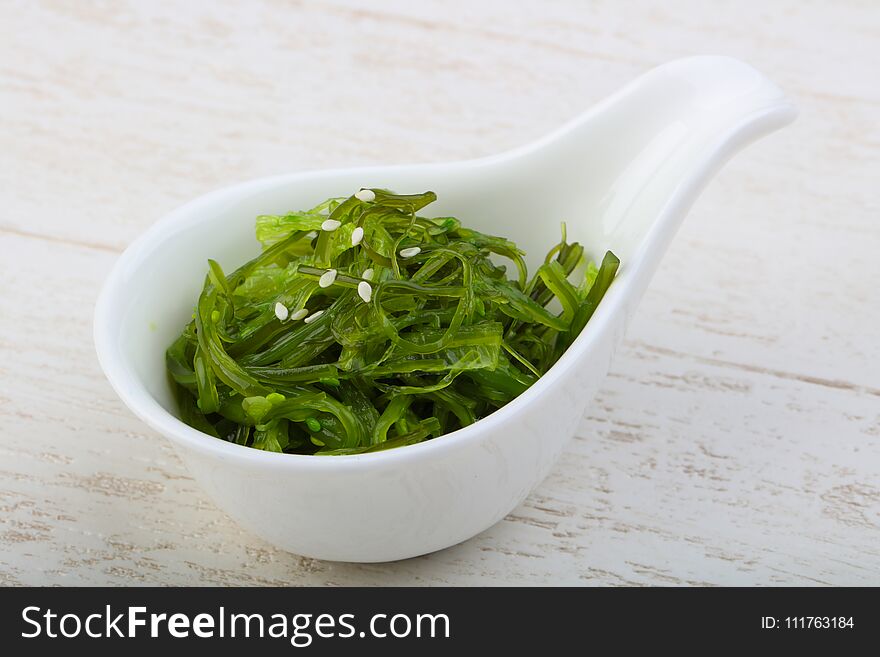 Chuka with sesame seeds in the bowl on wood background