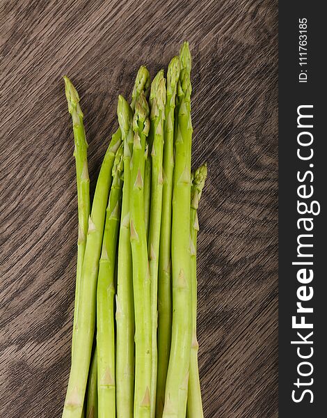 Raw green asparagus heap on the wood background