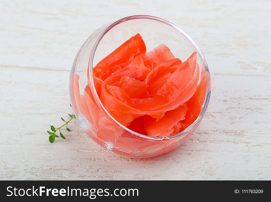 Pickled ginger in the bowl on wood background