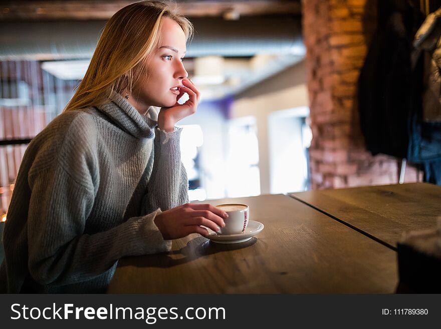 Young beauty woman in a cafe drinking coffee