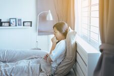 Young Asian Woman Coughing And Sitting On Her Bed Royalty Free Stock Photography