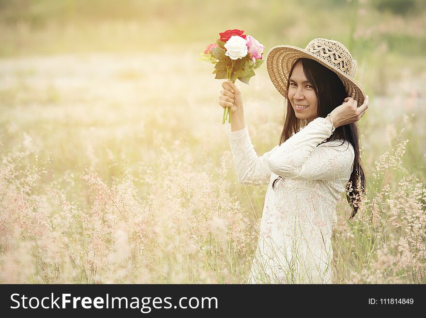 Portrait of a smiling young beautiful woman wear hat with a bouquet of roses flowers