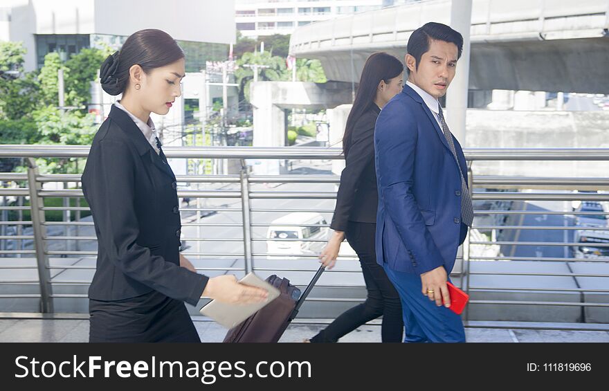 Group smart business people of men and women walk together in rush hour in feeling stress with tablet smart phone device and luggage at the outdoor pedestrian walkway space in the morning. Group smart business people of men and women walk together in rush hour in feeling stress with tablet smart phone device and luggage at the outdoor pedestrian walkway space in the morning.