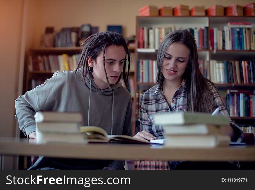 Two students learning together in library, front view.