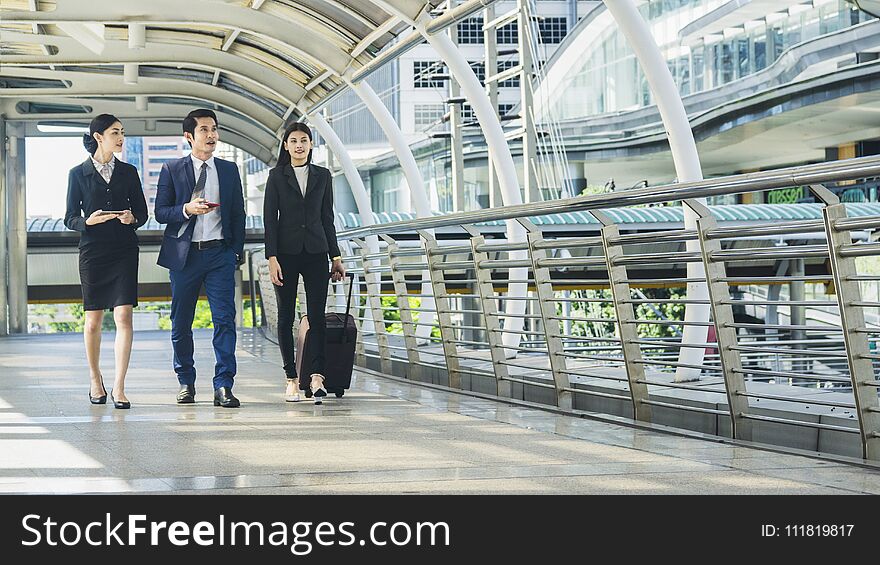 Business people walk outdoor pedestrian walkway