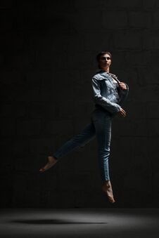 Ballet Dancer In Jeanswear Jumping In Dark Room Stock Photography