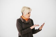 A Positive Modern Elderly Woman Holds A Tablet In Her Hands And Uses It. The Older Generation And Modern Technology. Stock Image A Positive Modern Elderly Woman Holds A Tablet In Her Hands And Uses It. The Older Generation And Modern Technology. Stock Image