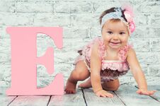 Beautiful And Cute Girl In Pink Dress With The Letter E. Emotional Girl. Royalty Free Stock Photo