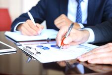 Two Young Businessmen Analyzing Financial Document At Meeting. Royalty Free Stock Image Two Young Businessmen Analyzing Financial Document At Meeting. Royalty Free Stock Image