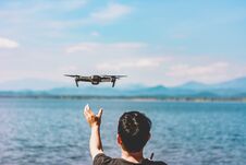 Man Releasing Flying Drone Quad Copter With High Resolution Digital Camera Flying The Sky With Lake View Royalty Free Stock Photos