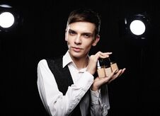 Young Male Make Up Artist Posing With Foundation For Make-up O Royalty Free Stock Images