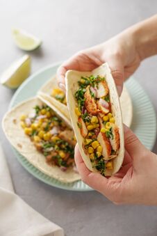 Hands Holding Tacos With Roasted Chicken Meat, Corn, Parsley, Salsa And Sweet Pepper. Royalty Free Stock Photography