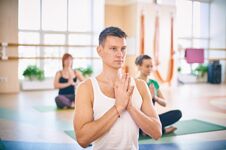 Group Of Young Sporty People Practicing Yoga Lesson With Instructor, Sitting In Padmasana Exercise, Lotus Pose With Folded Hands I Royalty Free Stock Photo