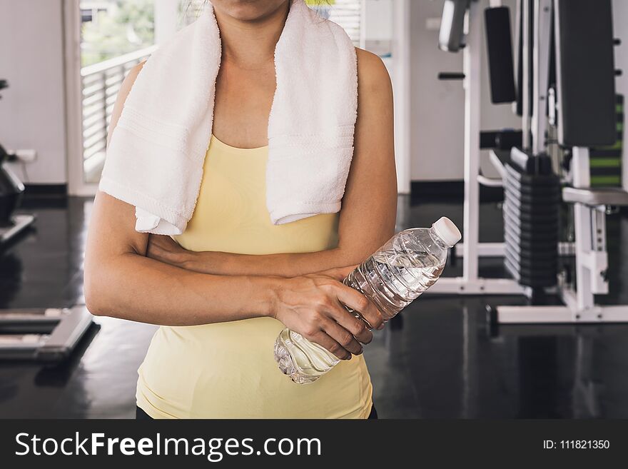 Fitness Woman With White Towel Holding A Bottle Of Water