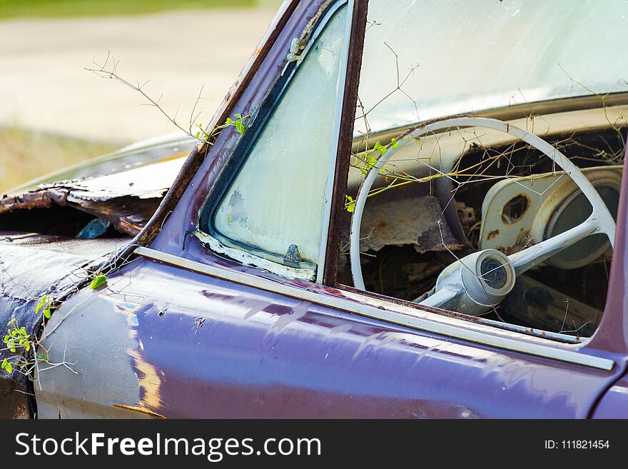Front view and steering wheel of an abandoned car.