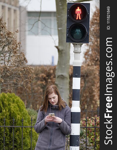 Young Woman Looks At Her Cellphone And Does Not Pay Attention To