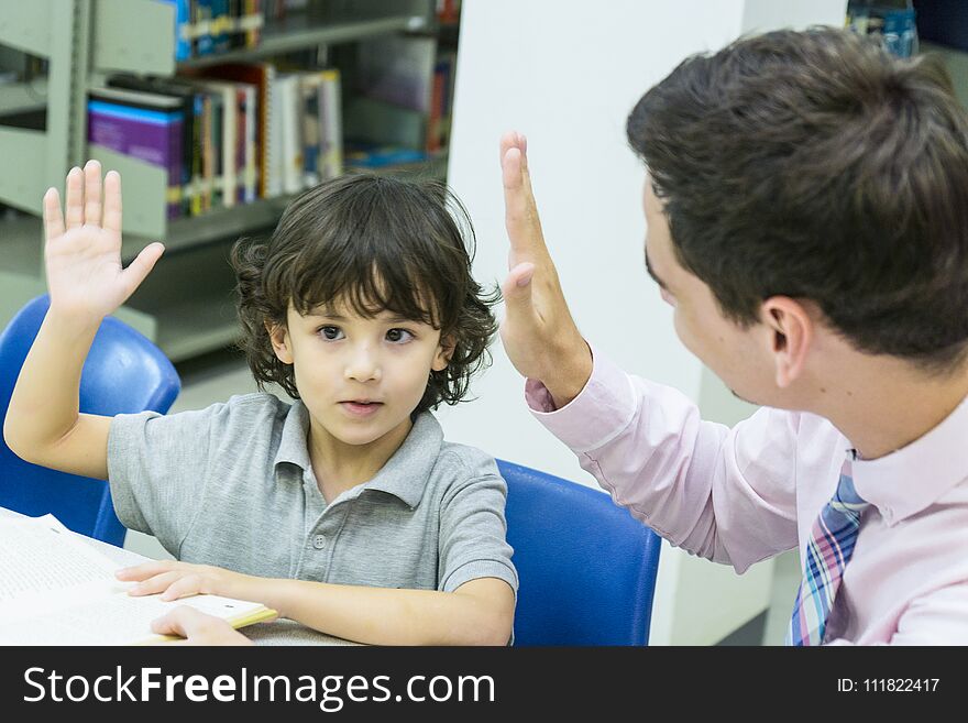Man teacher and kid student learn with book at bookshelf background