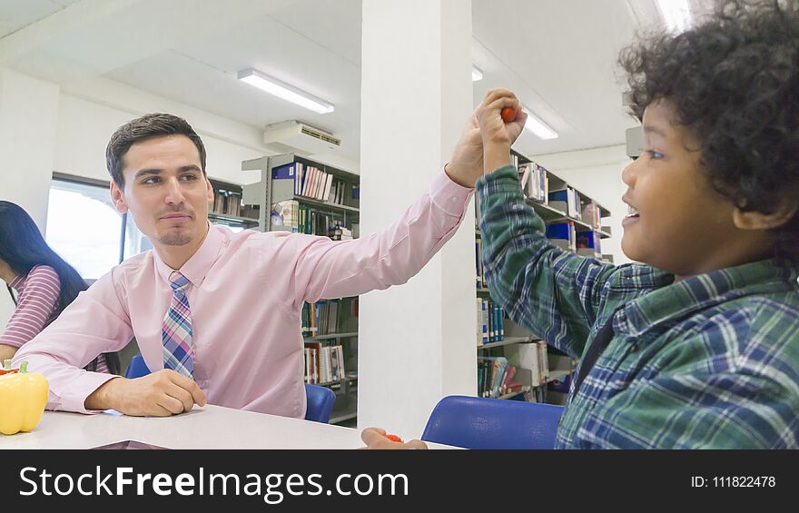 Man Teacher And Kid Student Learn With Book At Bookshelf Background