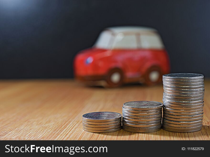 Saving money concept. coin stacks in front of car