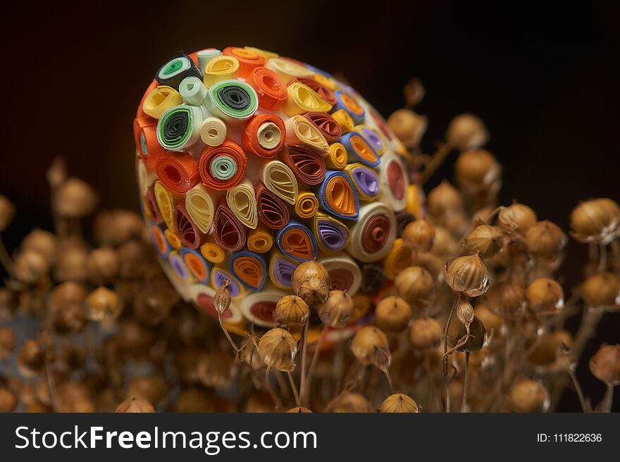 Easter eggs decorated with the quilling technique on the dried flax Linum bunch. Easter decor, selective focus. Easter eggs decorated with the quilling technique on the dried flax Linum bunch. Easter decor, selective focus.