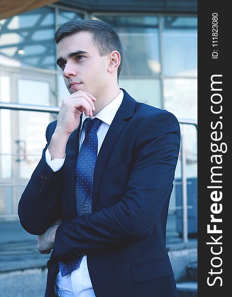 Close up.pensive businessman on background of office building.