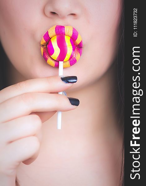Woman Holding Yellow and Pink Candy