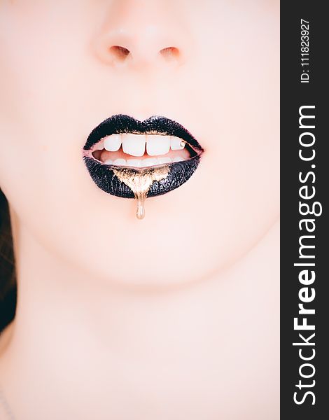 Woman Wearing Black Lipstick With Gold Dripping Out