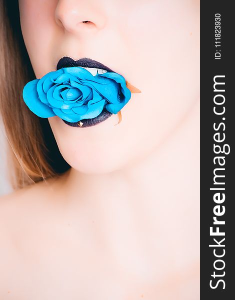 Woman With Black Lipstick Biting Blue Rose