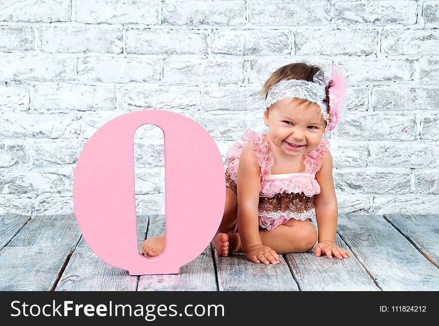 Beautiful And Cute Girl In A Pink Dress With The Letter O. Emotional Girl.