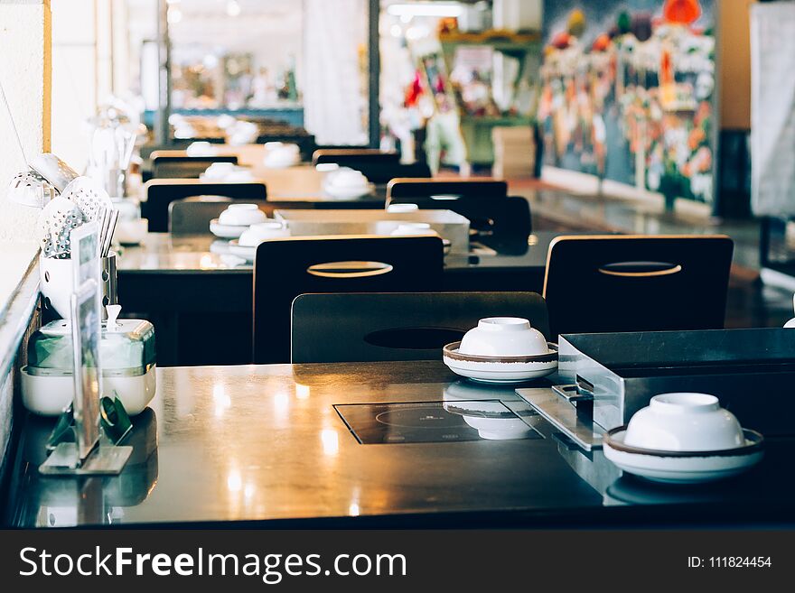 Table setting and electric stove in restaurant. Table setting and electric stove in restaurant.