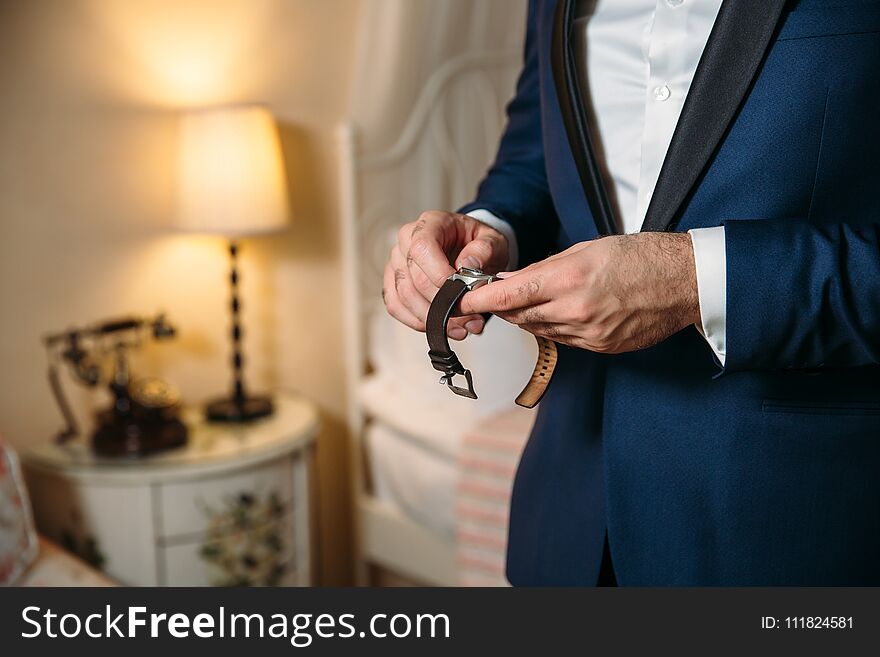 Businessman checking time on his wristwatch. men`s hand with a watch.